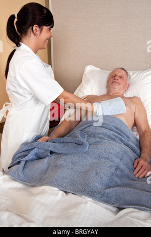 Eine Krankenschwester wäscht ein patient Stockfoto