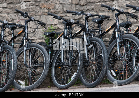 Eine Reihe von Fahrräder zum Verkauf geparkt gegen eine Steinmauer in Bradford-on-Avon, Wiltshire, UK-September 2010 Stockfoto