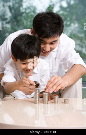 Vater und Sohn, die Berechnung der Münzen Stockfoto