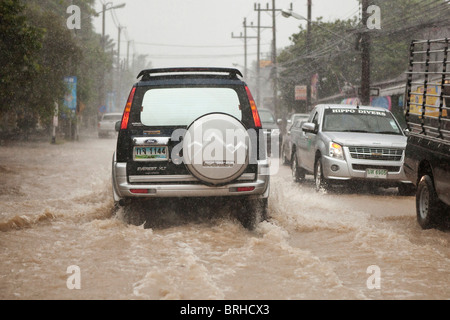 Verkehr auf überfluteten Straßen während der Regenzeit in Thailand Stockfoto