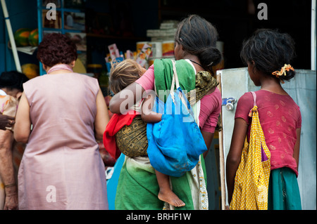 Betteln, Indian Street Mutter und Kinder, die ein westlicher Tourist beäugte Stockfoto