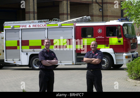 Zwei Feuerwehrleute mit ihrer Pumpe UK Stockfoto