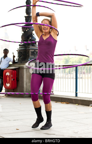 Hula-Hooper Lisa Lotti führt auf der Londoner South Bank mit Big Ben im Hintergrund.