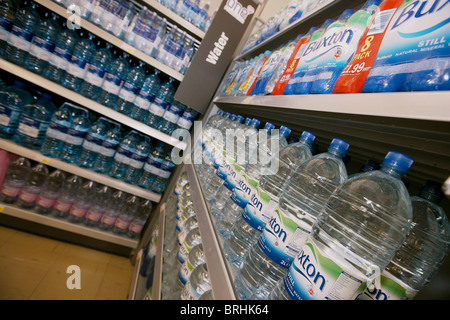 Mineralwasser für den Verkauf in einem Supermarkt gestapelt auf Regal, UK Stockfoto