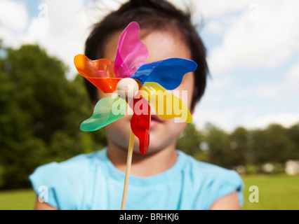 Kleiner Junge hält ein Windrad Stockfoto