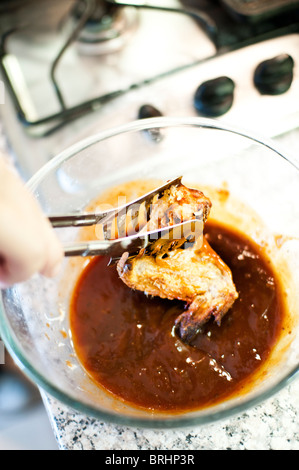 Hähnchenflügel, eingetaucht in BBQ-sauce Stockfoto