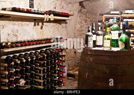 Ein alter Weinkeller mit einer Sammlung von Weinen und Flaschen in Racks. Stockfoto