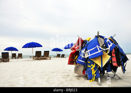 Sonnenschirme, Stühle und Schwimmwesten auf einsamen Strand. Stockfoto