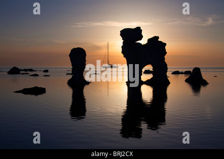 Segelschiff und erodierten Seastacks in Gamla Hamnøya bei Sonnenuntergang in Fårö, Schweden Stockfoto
