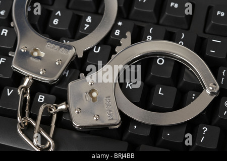 Handschellen auf einer Computertastatur Stockfoto