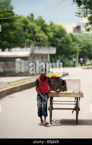 Indien Teenager Straßenhändler verkaufen gekochte Maiskolben. Puttaparthi, Andhra Pradesh, Indien Stockfoto