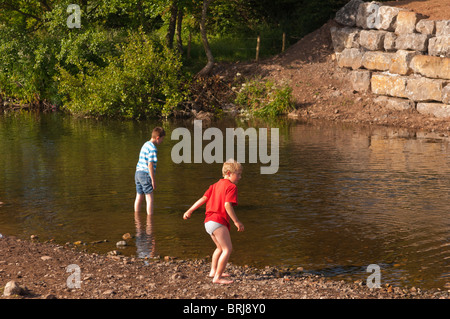 Zwei Modell veröffentlicht Boys (6 & 10) spielen im Fluss Ehen in Egremont, Cumbria, England, Großbritannien, Uk Stockfoto