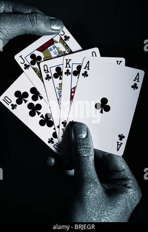 Metall-Männerhände mit Spielkarten auf schwarzem Hintergrund Stockfoto