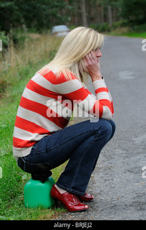 Frau Autofahrer sitzen auf einem Brennstoff kann am Straßenrand Stockfoto