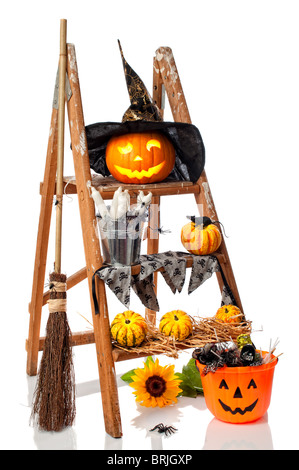 Halloween Jack O Lantern Kürbis Trittleiter mit Hexenbesen auf weißem Hintergrund Stockfoto