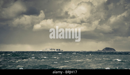 Ferne Gunkanjima oder Hashima, eine Insel in der Nähe von Nagasaki, in einem Sturm mit Wellengang. Getönten Image. Stockfoto