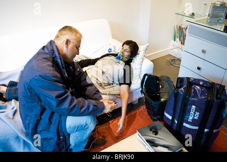 Verabreichung von Sauerstoff an Patienten im Hause auf Abruf-Notarzt Stockfoto