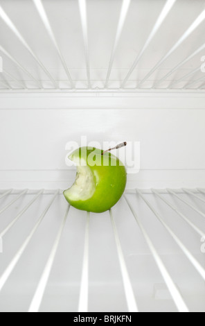 Einzigen Apfel mit Biss Mark auf Regal im Kühlschrank Stockfoto