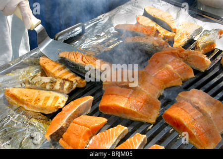 Ein Grill, eine heiße Flamme und Lachs umgewandelt in Rauch - Grillparty ein perfektes Wochenende oder einen Urlaub auf einem Luxus-Kreuzfahrtschiff Stockfoto