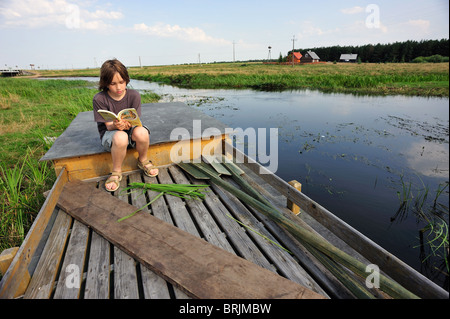 Biebrza River National Park, kleiner Junge liest ein Buch auf Beobachtung Schreibtisch eines Bündels Stockfoto