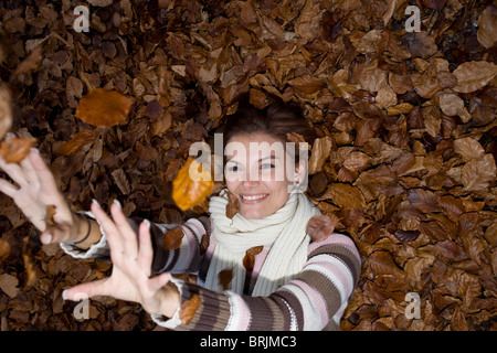 Frau in Blättern Stockfoto