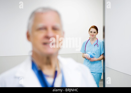 Krankenschwester mit Bewunderung auf Arzt Wand gelehnt Stockfoto