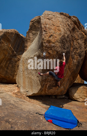 Kaukasische männliche Bergsteiger auf einem Highball-Boulder in Hampi, Indien. Stockfoto