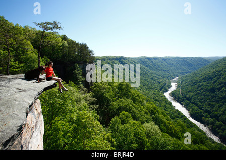 Frau und ihr Hund genießen Sie den Ausblick von einer hohen Klippe. Stockfoto