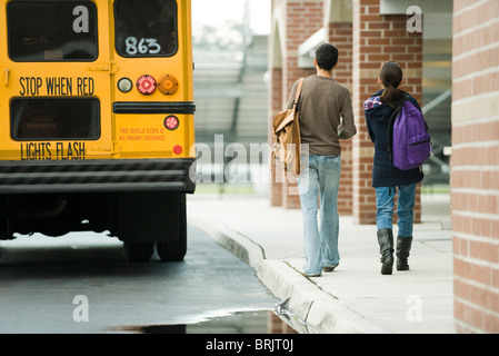 Schülerinnen und Schüler zu Fuß in Richtung Schulbus Stockfoto