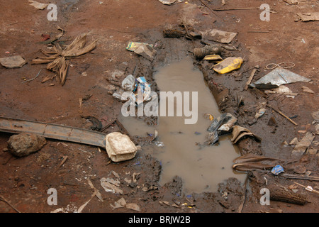 Müll Müll eine unbefestigte Straße mit Wasser gefülltes Schlagloch in Gulu, Norduganda Stockfoto