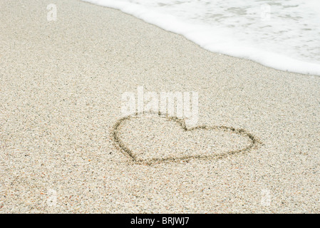 Herz im Sand am Strand gezogen Stockfoto