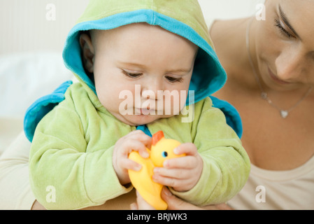Baby spielt mit Gummiente vor dem Baden Stockfoto