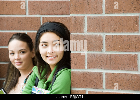 Teenager-Mädchen mit Freund, um Ecke spähen Stockfoto