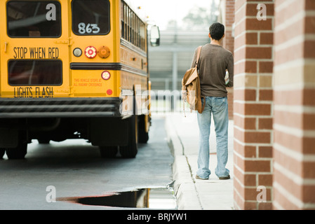 High-School-Schüler außerhalb der Schule für Bus warten Stockfoto