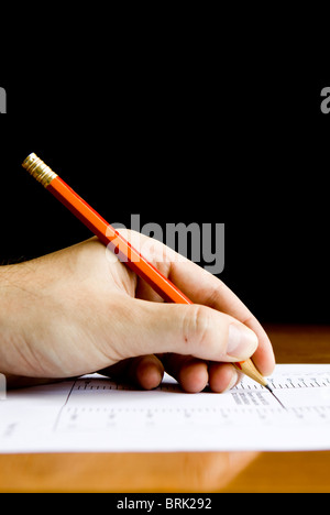 Nahaufnahme der Hand mit einem Bleistift auf ein Dokument. Viel Platz für die Kopie. Stockfoto