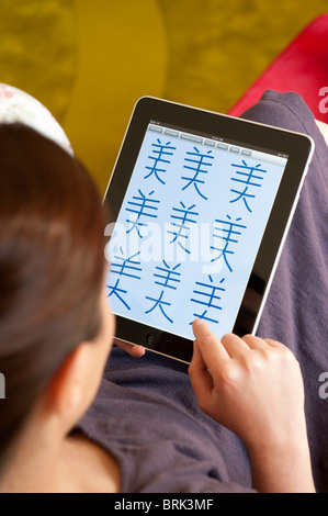 Frau, üben, um Mandarin chinesische Schriftzeichen auf einem iPad Tablet-Computer schreiben Stockfoto