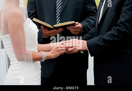 Braut und Bräutigam Hand in Hand im Ring Austausch Teil einer im freien Hochzeitszeremonie Stockfoto