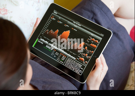 Überprüfung der Börsenentwicklung eine Finanz-app auf einem iPad Tablet-Computer mit Frau Stockfoto