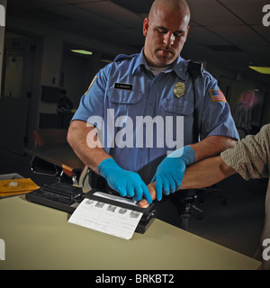 Polizist, Wachmann, Fingerabdrücke kriminelle verdächtige gefangen. Stockfoto