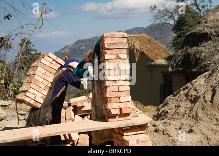 zwei Frauen tragen Ziegel auf einer Baustelle Stockfoto