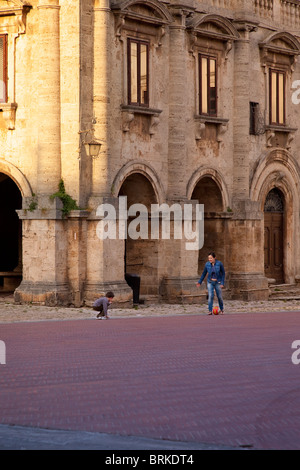 Mutter und Sohn spielt Fußball auf der Piazza Grande in Montepulciano, Toskana Italien Stockfoto