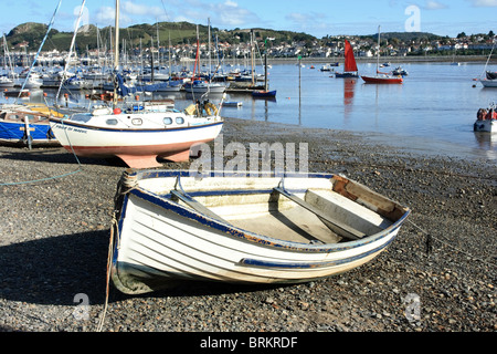 Kleine Boote, die auf einem Kiesstrand in Conwy hochgezogen Stockfoto