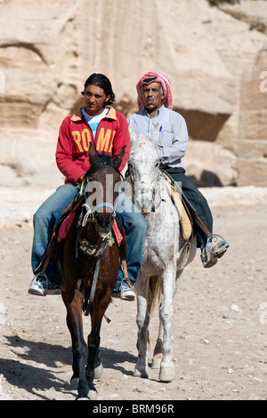 Touristen auf Reiten an den Siq, Canyon Eingang zum alten Felsen geschnitzt Stadt Petra, Jordanien. Stockfoto