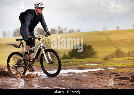 Mann fahren Mountainbike durch Schlamm Stockfoto