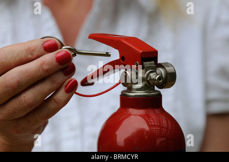 Entfernen der Metall Sicherheitsnadel aus einem Feuerlöscher Stockfoto