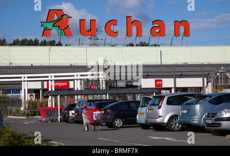 Mann mit Einkaufswagen auf Parkplatz am Auchan Supermarkt Frankreich Stockfoto