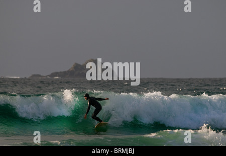 Ein Surfer auf einer Welle an Sennen in Cornwall. Stockfoto