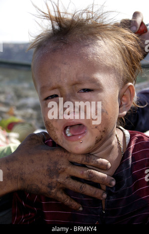 Ein junges Kind Arbeiter Junge weint in einer Müllkippe bei Stung Meanchey Mülldeponie in Phnom Penh, Kambodscha. Stockfoto