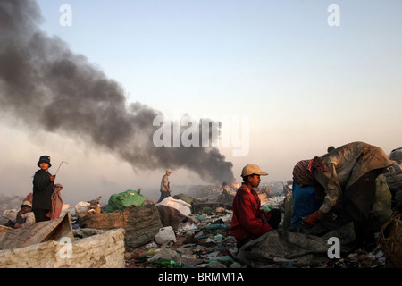 Der Himmel beginnt, mit Rauch aus der Verbrennung von Müll auf Stung Meanchey Deponie in Phnom Penh, Kambodscha zu füllen. Stockfoto