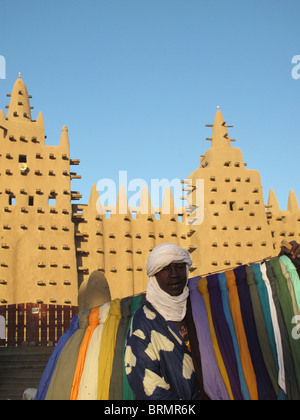 Ein Mann verkauft bunte Turbane vor Djenne Moschee, die größte Schlamm-Struktur in der Welt zuerst 1907 erbaut Stockfoto